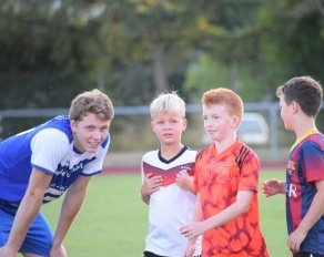 Trainer kümmert sich um Kinder