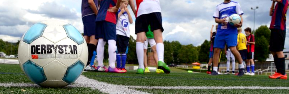 Kinder mit Ball beim Fußball in den Ferien